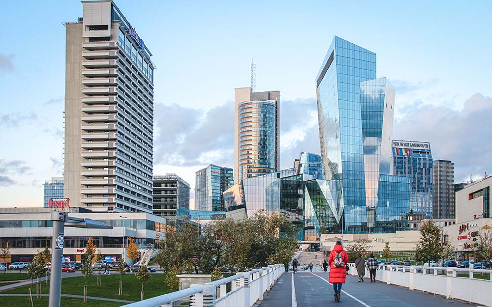 Женщина с гражданством Литвы едет на самокате по улице Риги