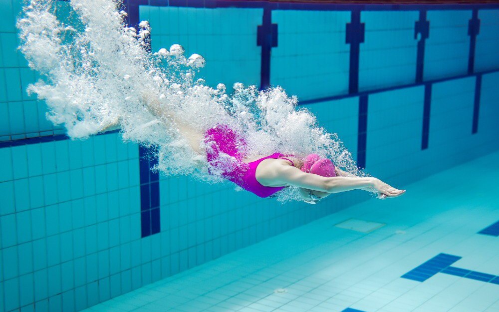 Девушка нырнула и скользит под водой
