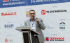 Борис Теклин, директор по техносферной безопасности Tablogix, с микрофоном на фоне логитипов участников форума Склады России