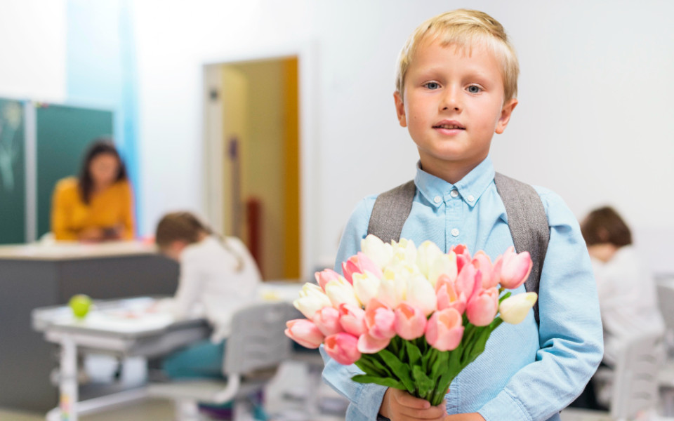 Ребенок с цветами в школьном классе